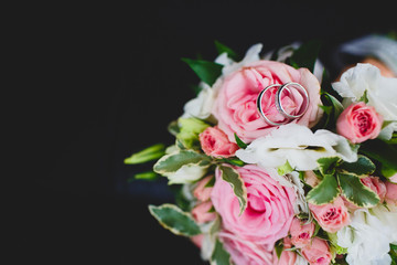 Obraz na płótnie Canvas Wedding diamond rings on bride's bouquet