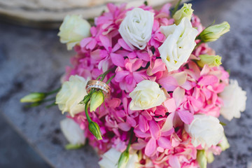 Wedding rings on pink bouquet