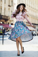 Outdoor full body portrait of young beautiful fashionable happy lady posing on street of the old...