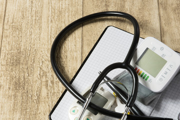 stethoskope on wooden desk with blood pressure measurement copy