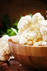 Inflorescences of cauliflower in a wooden bowl, vintage backgrou