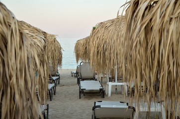 Sunbeds and parasols at the end of the day on the beach in Greece