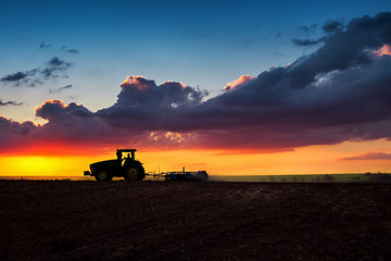 Farmer in tractor preparing land with seedbed cultivator