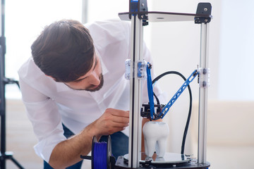 Pleasant man using 3d printer 