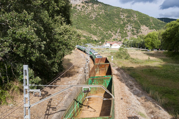 Freight train on an Iberian gauge railway track between Leon and Gijon on its way through La Pola de Gordon, Leon Province, Spain