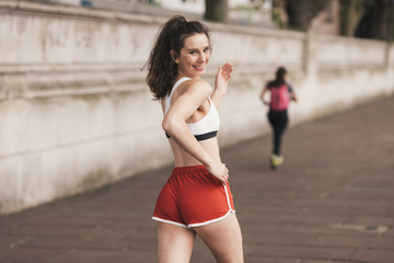 Young female runner looking over her shoulder whilst running