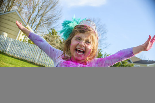 Girl in gown with feather fascinator playing outdoors