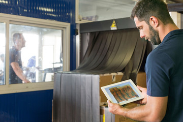 Supervisor checking xray using digital tablet in air freight warehouse