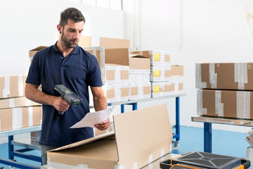 Warehouse worker scanning paperwork in distribution warehouse