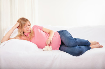 Pregnant woman relaxing at home on the couch