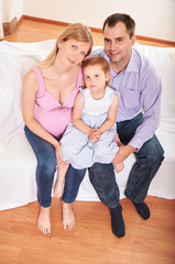 Fototapeta na wymiar Young pregnant woman, with husband and little daughter 