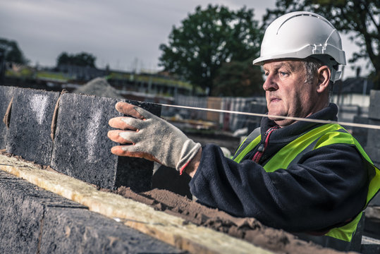 Workers laying bricks on construction site
