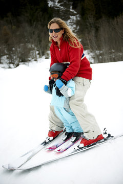 Male toddler in front of mother skiing downhill, Les Arcs,Villaroger,Savoie,France