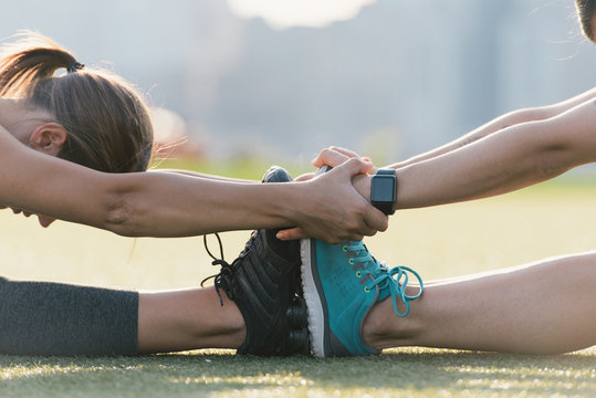 Two friends warming up to exercise together outdoors
