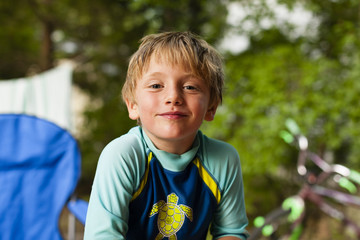 Portrait of boy wearing swimwear looking at camera smiling