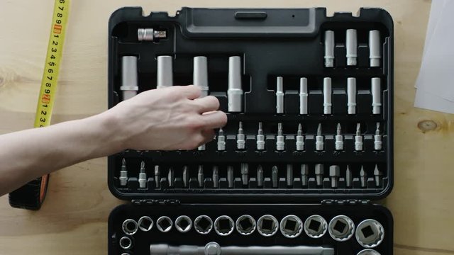 man open the toolbox  and take the tool from it