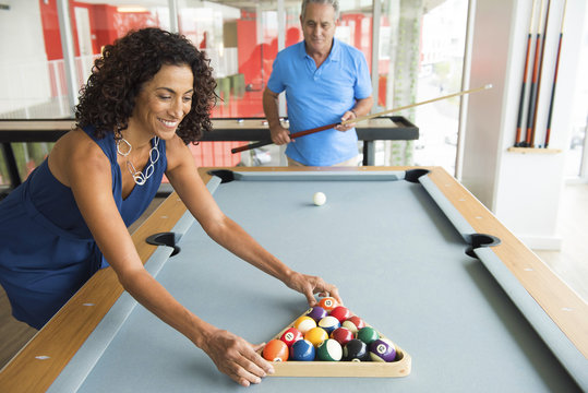 Senior man and wife setting up pool table