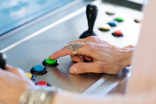 Close up of senior womans hand pressing button on games machine