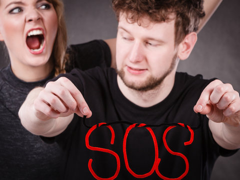 Young couple with broken heart and sos word.