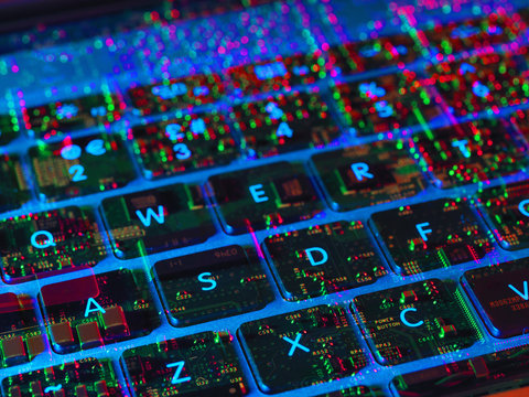 Double exposure of the inside and out of a laptop computer showing the electronic components under the keyboard