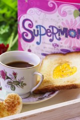 Cup of coffee and Egg in a hole with Mother's day card in background, selective focus