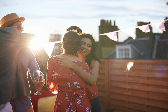 Friends Congratulating Couple At Early Evening Engagement Party