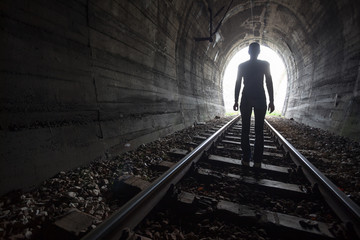 Man in a tunnel looking towards the light