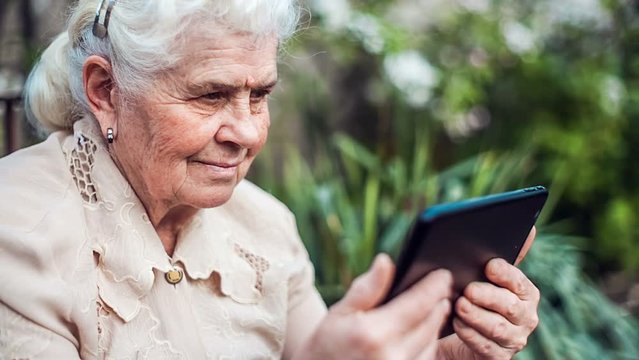 Senior woman taking pictures with tablet