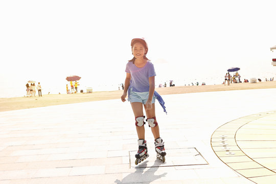 Girl rollerblading at beach, Zhuhai, Guangdong, China