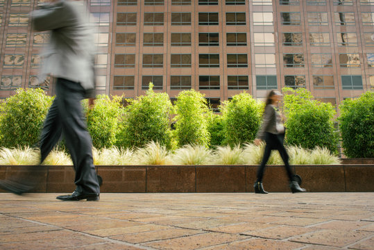 Businessman And Woman Walking In Opposite Directions