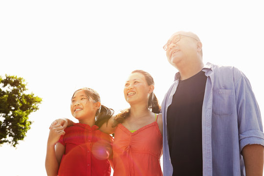 Parents and daughter strolling in sunlight