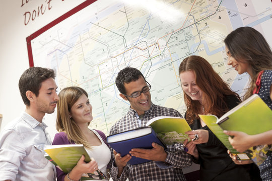 Small group of people, looking through study books