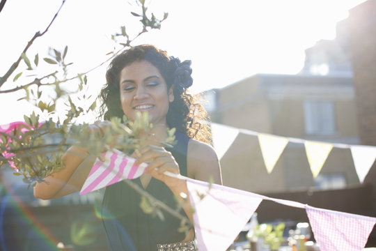 Woman hanging bunting for early evening party