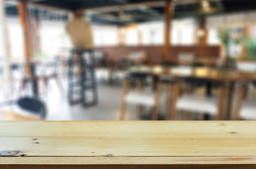 Selected focus empty brown wooden table and Coffee shop blur bac