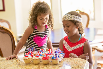 Girls looking at american flag theme decorated cupcakes