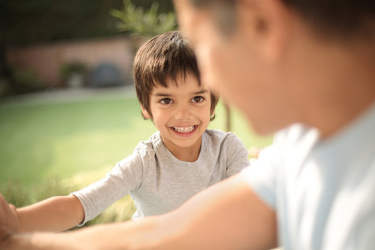Boy in garden smiling at father, differential focus