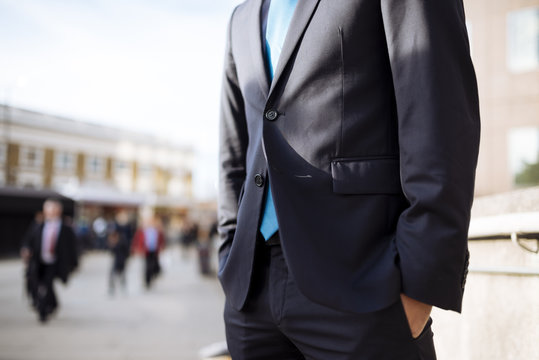 Businessman with hands in pocket, partially obscured, London, UK