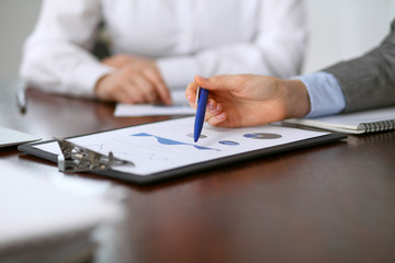 Fototapeta premium Close up of unknown business people at meeting discussing financial results