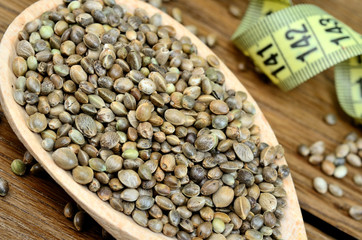 Hemp seeds in a wooden spoon with centimeter