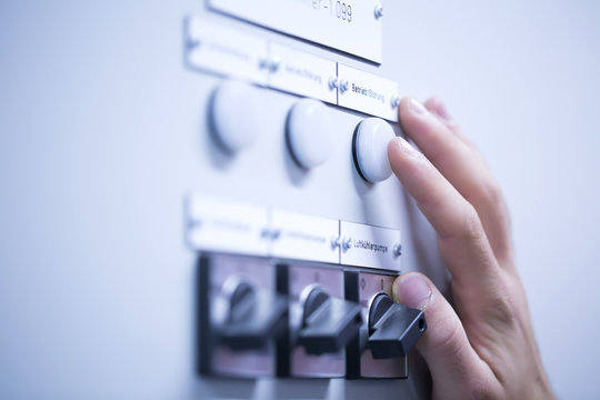 Cropped view of young mans hand adjusting dial on switchgear