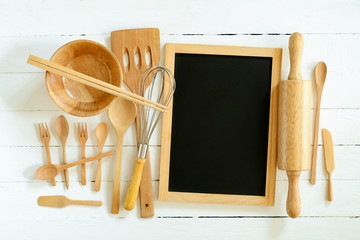 Overhead view of wood utensils and chalkboard on wood board back