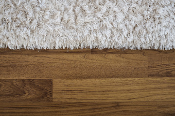 Close up fluffy luxury carpet on laminate wood floor