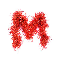 Tinsel Christmas decoration in form of M. On a white background