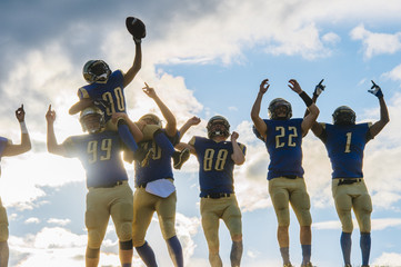 Group of young american football players, celebrating