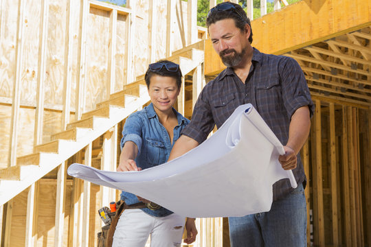Mid adult woman discussing floor plans with builder