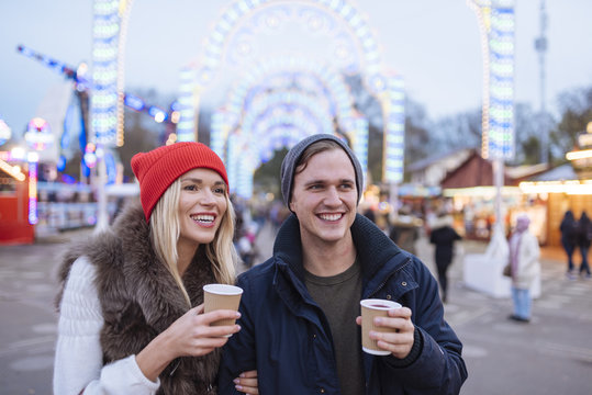 Happy young couple drinking mulled wine at Christmas festival