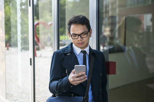Young asian man looking at mobile phone
