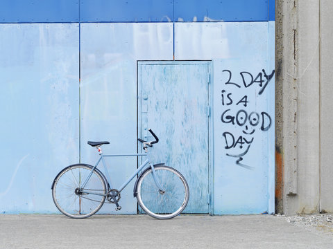 Bicycle parked against graffiti wall