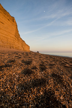 Shingle beach and cliffs at dusk, Burton Bradstock, Dorset, UK