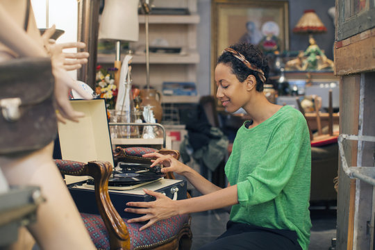 Young woman playing vinyl records in vintage shop
